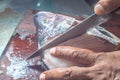 How to scrape tilapia fish using a knife,man wiping a fish on a wooden table Royalty Free Stock Photo