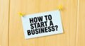 HOW TO START A BUSINESS sign written on sticky note pinned on wooden wall Royalty Free Stock Photo