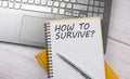 HOW TO SURVIVE text written on a notebook on the laptop