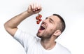 This is how vegan like raw and good farmer vegetables. Man is holding a ramus of ripe and red small tomatoes and want to