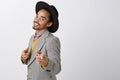 How you doing, babe. Portrait of confident dark-skinned macho man in stylish hat and gray jacket pointing index fingers Royalty Free Stock Photo