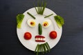 How you eat, that`s how you look. Eggs, radish, lettuce and tomato on a plate with pepper forming a face. Royalty Free Stock Photo