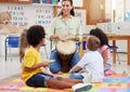 This is how you play it. Shot of a woman teaching her class about musical instruments. Royalty Free Stock Photo