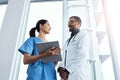 How is your patient doing. two young doctors using a digital tablet in a modern hospital. Royalty Free Stock Photo