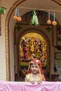 Howrah,India -October 26th,2020 : Bengali girl child posing with Goddess Durga in background, inside old age decorated home. Durga