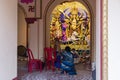 Howrah,India -October 26th,2020 : Bengali sari clad mother, showing Goddess Durga to child, Durga inside old age decorated home.