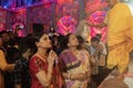 Hindu Bengali sari clad women praying to Goddess Durga inside Durga Puja pandal. Ashtami puja aarati at night. Biggest fetsival of Royalty Free Stock Photo