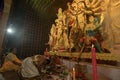 Hindu Priest showing respect, praying and worshipping Goddess Durga, kneels down position. Puja Pandal. Durga puja is unesco