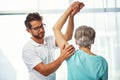 Hows that rotator cuff. a senior woman working through her recovery with a male physiotherapist.