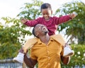 Hows the weather up there. an adorable little boy enjoying a piggyback ride with his father in a garden. Royalty Free Stock Photo