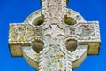 Old stone celtic cross on a bright clear blue sky background Royalty Free Stock Photo