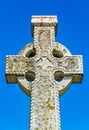 Old stone celtic cross on a bright clear blue sky background Royalty Free Stock Photo