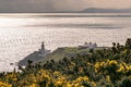 Howth Lighthouse on the peninsular of Dublin Bay Silhouetted against the morning sun Royalty Free Stock Photo
