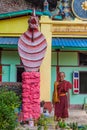 HPA AN, MYANMAR - DECEMBER 13, 2016: Snake naga statue and an elderly monk near Saddan cave near Hpa An, Myanm