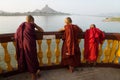 Three monks standing at the pagoda along the river with mountain in Hpa-an, Myanmar Royalty Free Stock Photo