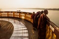 Three monks standing at the pagoda shined with last sun along the river in Hpa-an, Myanmar Royalty Free Stock Photo