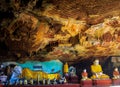 View into buddhist cave with colorful buddha statues and mural paintings