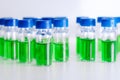 HPLC vials with green sample of plant extracts. Developing of drugs based on natural products. Biochemical analysis