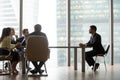 Hr team interviewing african candidate sitting at table in office