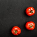 Hree ripe tomatoes on black background. The whole vegetable