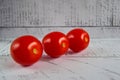 Hree tomatoes diagonally on a wooden background close-up. Vegetarian healthy food.