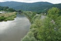 Hron river in Zarnovica region in central Slovakia with trees and bushes thickly growing on the right river bank.