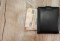 500 hryvnia in a black men`s wallet on a wooden background. View from above. Copy space. Place for text. Royalty Free Stock Photo