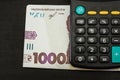 1000 hryvnia and calculator on a black background. Close-up. Financial concept.