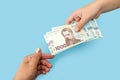 1000 hryvnia in female hands. The concept of corruption. to give a bribe. Give or take dollars. Hands with hryvnias on a