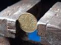 Hryvnya coin clamped in a metal vise. Currency and Ukrainian economy under the onslaught, the concept of financial problems