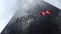 HSBC logo on a skyscraper facade reflecting clouds. Editorial 3D rendering