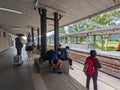 Passengers with luggage and backpacks waiting for a local train on the platform in Fuli Railway Station on a sunny day Royalty Free Stock Photo