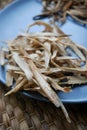 Huang Qi Astragalus root sliced and dried on a plate.