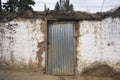 huanuco peru poor and abandoned house with dirty adobe wall with closed door street and sidewalk