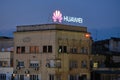 Huawei logo on top of a building with dilapidated exterior in Eastern Europe, at sunset. Bucharest, Romania - May 9, 2020 Royalty Free Stock Photo