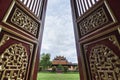 Hue, Vietnam - June 2019: view over traditional Vietnamese temple through open decorated entrance doors