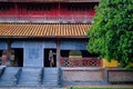 Hue / Vietnam, 17/11/2017: Woman standing inside a traditional house with ornamental tiled roof in the Citadel of Hue, Vietnam