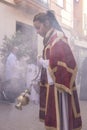 Huelva, Spain - April 10, 2022: Female Altar boy or acolyte in the holy week procession shaking a censer