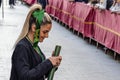 Huelva, Spain - April 13, 2022: A young woman from the brotherhood of Veracruz is doing the penance station in the Holy Week