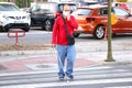 Huelva,Spain - May 8,2020: Blind person with white stick walking on street and crossing a crosswalk. He is wearing protective mask