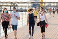 Huelva, Spain - May 23, 2020: People walking by Huelva promenade at sunset, wearing protective or medical face masks during the