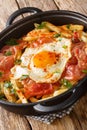 Huevos rotos con jamon fried egg with fries and ham close-up in a pan. vertical Royalty Free Stock Photo