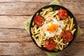 Huevos Rotos with fried potatoes and chorizo close-up in a plate. Horizontal top view