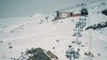 HUEZ, FRANCE - FEBRUARY 29, 2024. Alpine skiing slope and chairlift or ski lift on the mountain in Alpe d'Huez