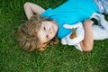 Hug friends. Cute child playing with chihuahua mixed dog lying on backyard lawn. Royalty Free Stock Photo