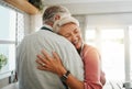 Hug, love and safe with a senior couple hugging or embracing in the kitchen of their home together. Happy, smile and