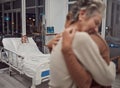 Hug, support and family at hospital with father lying in bed sick with cancer or illness. Sad, comfort and senior woman Royalty Free Stock Photo