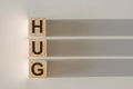 HUG - wooden blocks with shadows on light background Royalty Free Stock Photo