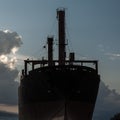 A huge ship thrown on the black sea coast close-up at sunset