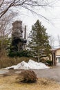 Huge Ainu statue with pine trees and pile of snow in the area of Shiraoi Ainu Village Museum in Hokkaido, Japan